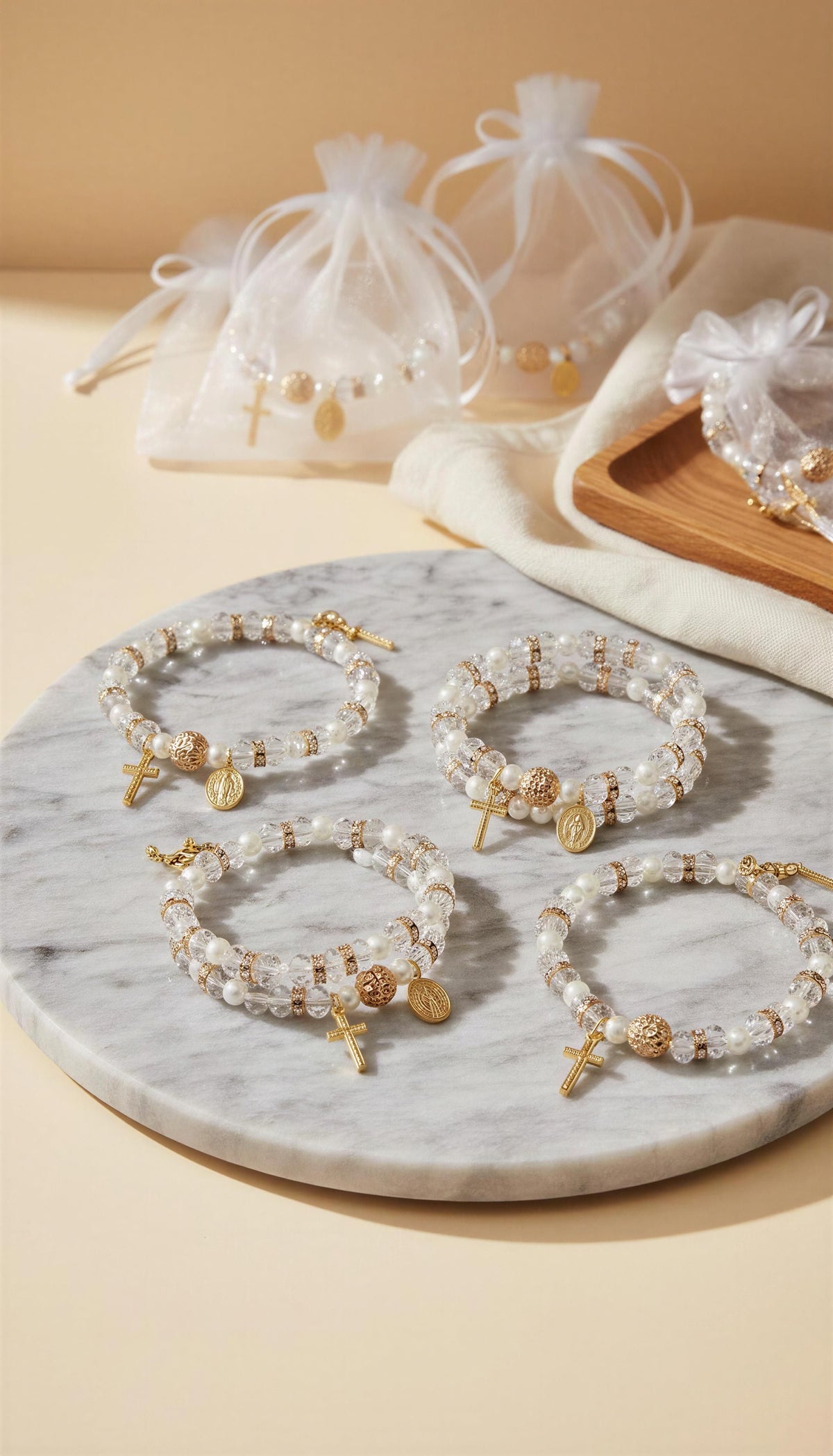 Set of pearl and gold beaded bracelets on a marble surface with decorative bags in the background.